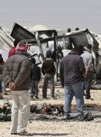 Syrští uprchlíci stojí nedaleko zničeného majetku v uprchlickém táboře Zaatarí