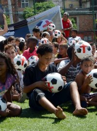 Brazílie, Rio de Janeiro, favela Jacarezinho. K rozdělení části zisku z MS ve fotbale mezi chudinské komunity vyzvala při setkání na hřišti nezisková organizace Rio Míru (Rio de Paz)