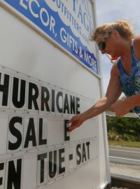 USA, Severní Karolína. Lidé v Buxtonu se připravují na příchod prvního letošního hurikánu. Na snímku žena před svým krámkem dokončuje ceduli upozorňující na mimořádnou slevu