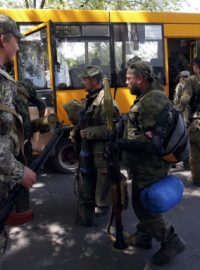 Ozbrojení poruští separatisté nastupují do autobusů, aby opustili své pozice v Kramatorsku