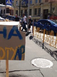 Dobrovolníci v ulicích Kyjeva natírají městský mobiliář na modro-žluto