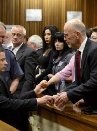 Oscar Pistorius se drží za ruce se členy své rodiny poté, co vyslechl rozsudek pěti let vězení za neúmyslné zabití přítelkyně