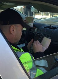 Policisté kontrolují doklady cizinců z osobního auta