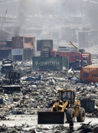 Buldozer odstraňuje sutiny poblíž místa exploze v přístavním městě Tchien-ťin na severovýchodě Číny