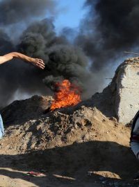 Palestinec hází kameny na izraelské jednotky při střetech nedaleko hranic Izraele a Pásma Gazy