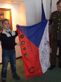 Školák Erik Palásek se státní vlajkou podepsanou českými vojáky v Afghánistánu