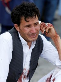 Zdrcený muž telefonuje po sebevražedném útoku v Kábulu, který si vyžádal přes 60 mrtvých