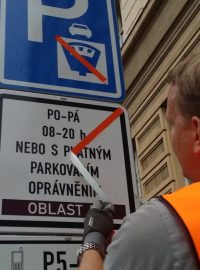 Na území Prahy 5 a 6 začaly platit zóny placeného stání. Na snímku pracovník firmy Eltodo strhává nálepku, která zneplaťňovala příslušné značky