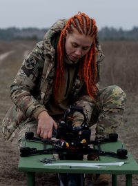 Ukrajinská vojačka připravuje dron, který je ve vzduchu připevněný k optickému vláknu