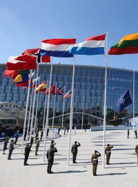 Na stožáry před novou centrálou NATO ve čtvrtek odpoledne poprvé vystoupaly vlajky 28 členských zemí i modrá vlajka NATO.