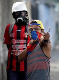 Demonstrant třílející prakem během protestů proti prezidentovi Nicolási Madurovi v Caracasu