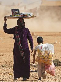 Matka s dítětem se živí prodejem potravin v uprchlickém táboře.