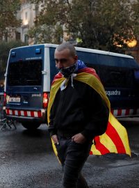 Muž v katalánské vlajce směruje na shromáždění před budovou španělské vlády v Barceloně