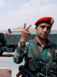 Syrský voják, v pozadí vojenské vozidlo s ruskou vlajkou (ilustrační foto)