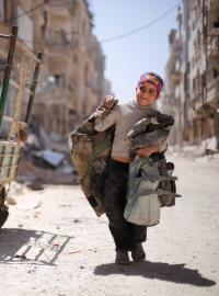 Chlapec jde po poničené ulici v Damašku