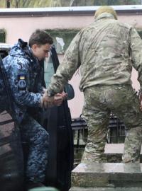 Člen ruské Federální bezpečnostní služby vede zadrženého ukrajinského námořníka k soudu v Simferopolu