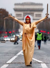 Žena v převleku za Spravedlnost a za jeden ze symbolů Francouzské republiky Marianne pózuje během protestů „žlutých vest“ poblíž Vítězného oblouku.