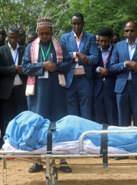 Členové somálské vlády se modlí nad tělem zabitého starosty Mogadiša Abdirahmana Omara Osmana.