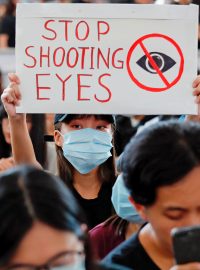 Někteří demonstranti na letišti mají pásky přes pravé oko, na transparentech se objevují nápisy „Nestřílejte do očí“ nebo „Zastavte ten masakr“.