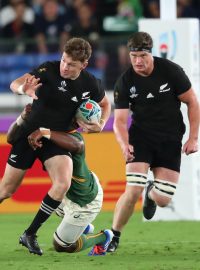 Beauden Barrett (uprostřed) následovaný svým bratrem Scottem v souboji s jihoafrickými ragbisty během zápasu na mistrovství světa