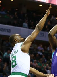 Kemba Walker (vlevo) blokuje střelecký pokus Dwayna Bacona