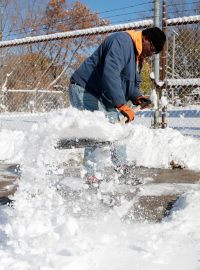 Muž odhazující sníh při rekordním poklesu teplot v USA během listopadu 2019