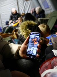 Irina z Mykolajivu ukazuje novinářům nahrávku, na které je hořící dům její kamarádky.