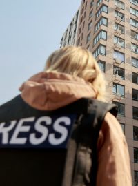 Novináři stojí před kyjevskou budovou zasaženou ruským ostřelováním