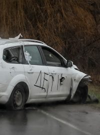 Zničený automobil s nápisem „Děti“ v ukrajinské Buče