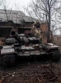 Ukrajinský voják seskakuje ze zničeného ruského tanku ve vesnici Mala Rogan na východě Ukrajiny