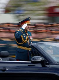 Ministr obrany přijíždí k pódiu za prezidentem Putinem