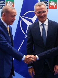 Turecký prezident Tayyip Erdogan a švédský premiér Ulf Kristersson si podávají ruce vedle generálního tajemníka NATO Jense Stoltenberga před jejich setkáním v předvečer summitu NATO ve Vilniusu