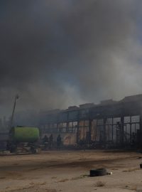 Policisté a hasiči pracují v Chersonu na místě skladů poškozených během ruského vojenského útoku na Ukrajinu.