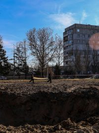 Kráter po dopadu ruské střely v ukrajinském Chersonu