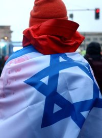 Muž s izraelskou vlajkou během protestu proti antisemitismu u Braniborské brány v Berlíně