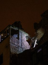 Pracovník záchranné služby kontroluje obytný dům poškozený při útoku ruského dronu