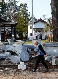 Muž prochází kolem poškozené svatyně po zemětřesení v Udžimě v prefektuře Ishikawa