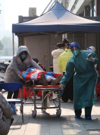 Zdravotníci odvážejí obyvatele Wu-chanu, který onemocněl covidem-19, do nemocnice