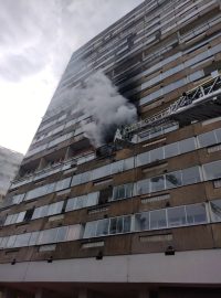 Hasiči zasahují u požáru bytu v panelovém domě na sídlišti v Březenecké ulici v Chomutově. Evakuovali 60 lidí