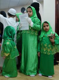 „Mír s vámi“, zpívají děti v přízemní hale modlitebny. Kluci mají na sobě bílý splývavý oděv, dívka zelené šaty.