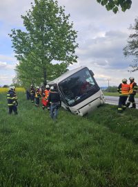 Autobus skončil v příkopě na boku opřený o strom