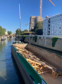 A právě teď po Seině připlouvá 80 metrů dlouhá loď a na ní dřevěná nosná konstrukce pro katedrálu Notre-Dame
