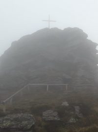 Dřevěný kříž je na skalnatém vrcholu hory Vozka v Jeseníkách