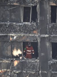 Hasiči prohledávají budovu Grenfell Tower po požáru.