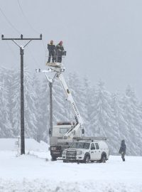 Energetici opravují izolátory na elektrickém vedení u lokality Lojzovy Paseky u Frymburku na Českokrumlovsku, které v noci na 28. dubna vyřadil z provozu mokrý sníh a padající stromy.