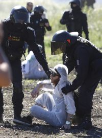 Dopoledne během protestního pochodu vybočily nečekaně zhruba dvě stovky lidí z vymezené trasy a pokusily se proniknout do lomu Bílina. Na místě je obklopili policejní těžkooděnci.