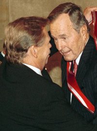 Na snímku ze 17. listopadu 1999 George H.W. Bush (vpravo) přebírá ve Vladislavském sále Pražského hradu z rukou Václava Havla nejvyšší české vyznamenání - Řád Bílého lva.