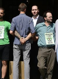 Několik členů hnutí Extinction Rebellion zablokovalo před polednem vchod do ministerstva pro místní rozvoj na Staroměstském náměstí