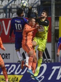 Brankář Mladé Boleslavi Jan Stejskal (ve žlutém) zasahuje proti hlavičce olomouckého Jakuba Yunise (v modrém).