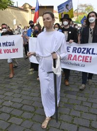 V čele průvodu šla žena, která v rukou držela symboly justice a spravedlnosti